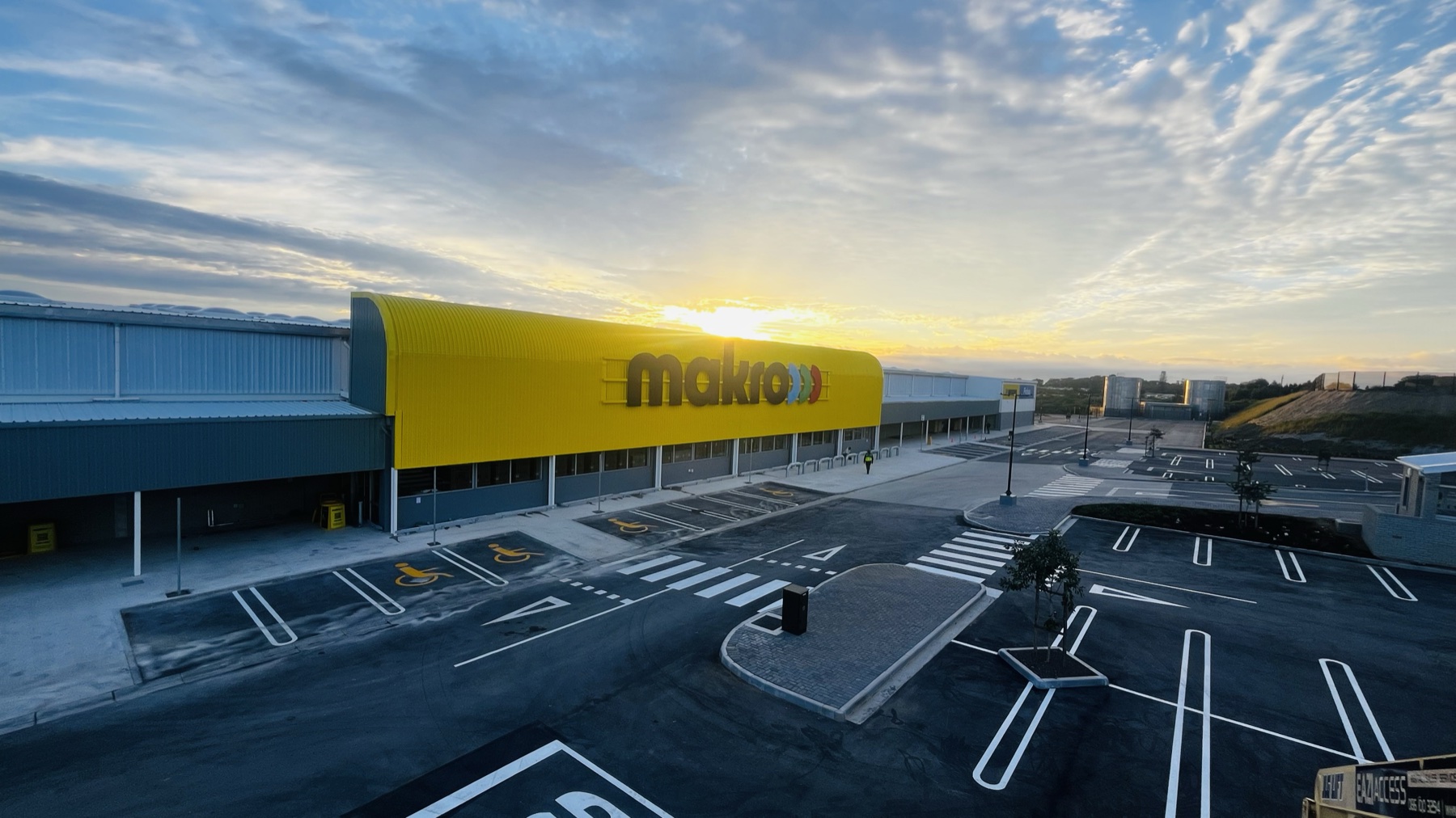 Large Makro exterior sign across a yellow store frontage at sunset
